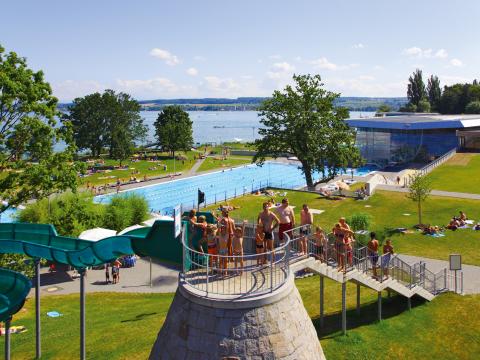 Blick über die große Außenrutsche im Freibad der Bodensee-Therme mit vielen Menschen auf der Treppe zur Rutsche.