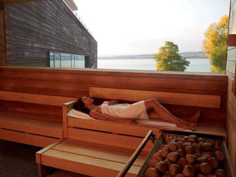 Frau liegend in der Panoramasauna mit Blick über den See