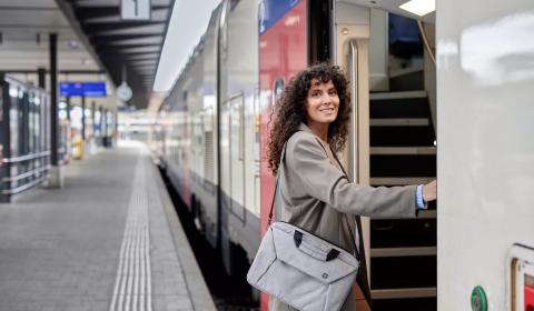 Frau steigt ein in einen Schweizer Zug